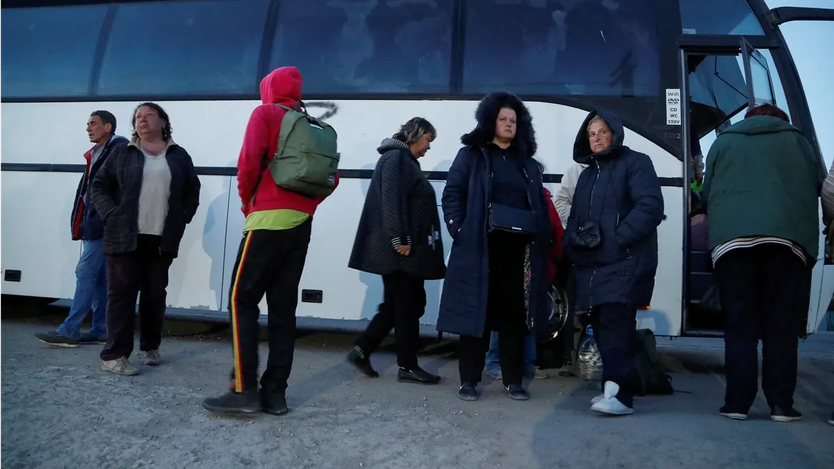 Эвакуированные из Мариуполя люди стоят возле автобуса в пункте временного размещения в Безыменном, Украина, 7 мая. Фото: Александр Ермоченко/Reuters