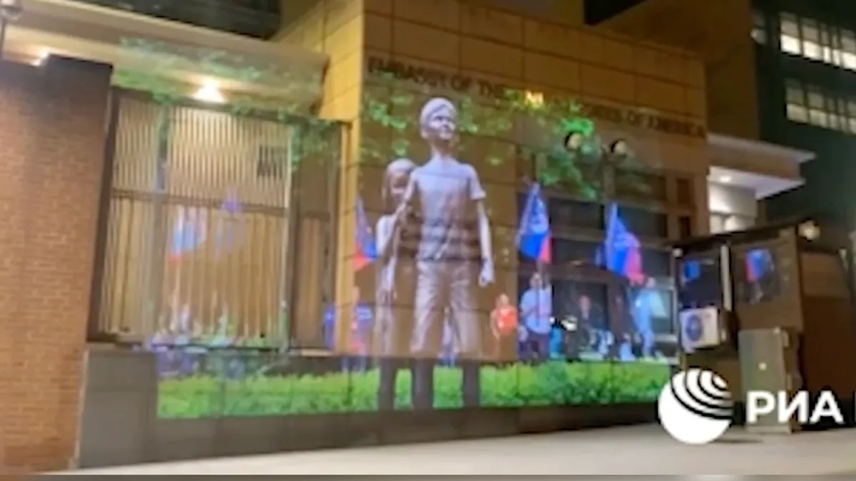 Ролик показали на стене посольства. Фото: стоп-кадр с видео РИА Новости