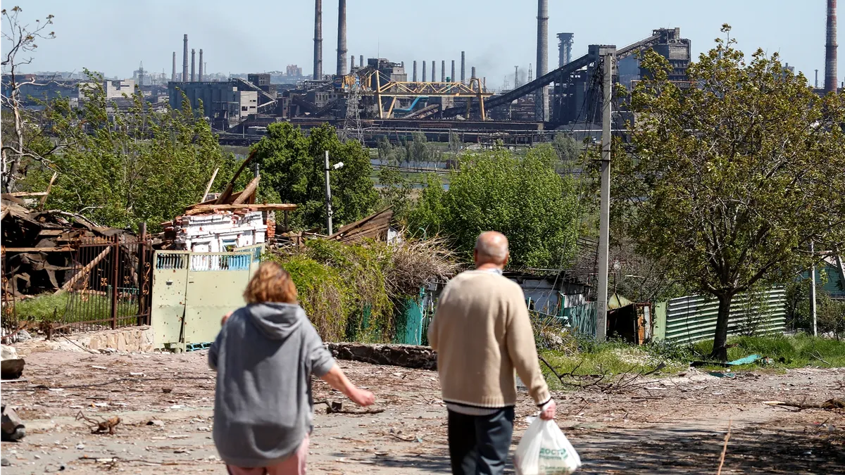 Люди идут возле сталелитейного завода «Азовсталь» в Мариуполе, Украина, 12 мая. Фото: Александр Ермоченко/Reuters