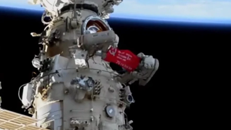 Два космонавта на видео разместили знамя в открытом космосе. Фото: скриншот видео РЕН-ТВ