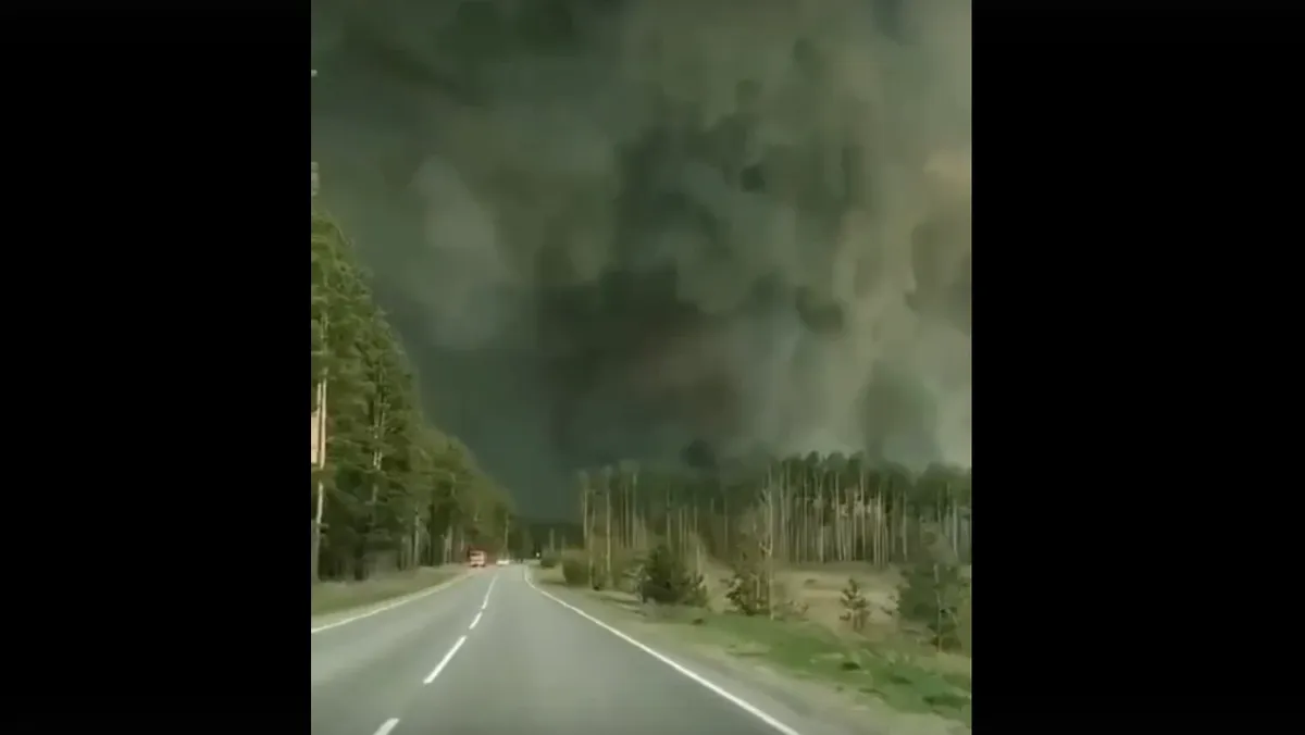 Под Тюменью гигантское черное облако от лесного пожара парализовало автомобильную трассу. Видимость нулевая - видео