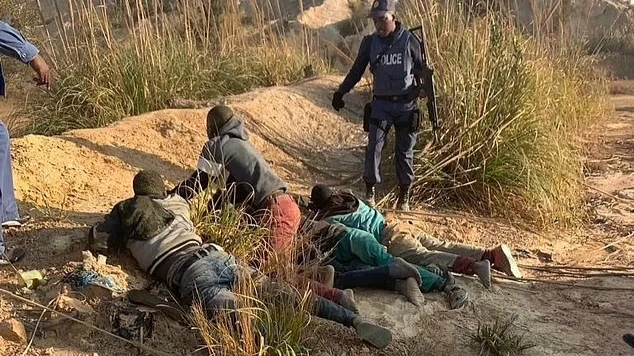 Южноафриканская полиция задерживает членов незаконного шахтерского лагеря недалеко от Крюгерсдорпа после ужасающего группового изнасилования восьми женщин на прошлой неделе. Фото: dailymail.co.uk 