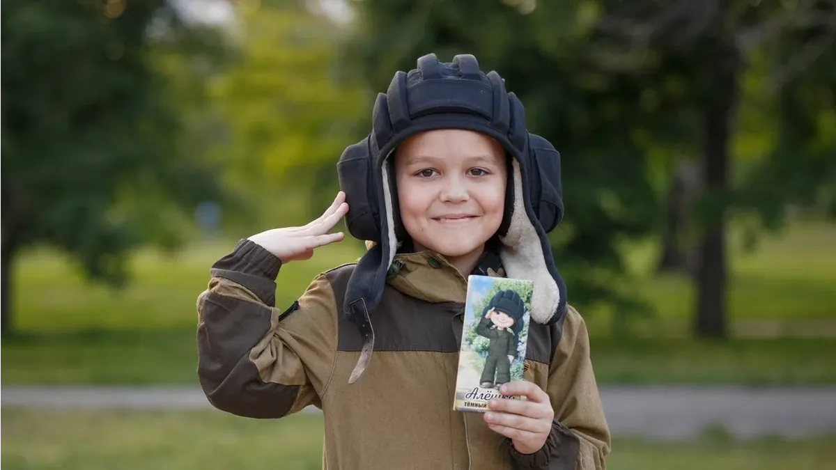 Ребенок стал известен тем, что встречает колонны военных и отдает им воинскую честь. Танкисты подарили мальчику настоящий шлемофон. Фото: телеграм-канал 